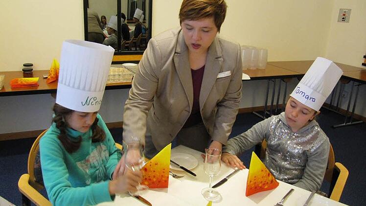Restaurant-Leiterin Nathalie Bauer erklärt das Eindecken der Tafel.