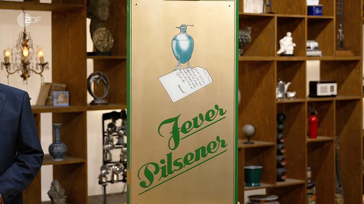Das Werbeschild war von Jever Pilsener, das seit 1848 in der friesischen Stadt Jever gebraut wurde. Lichter fiel jedoch vor allem das ungew&ouml;hnliche Motiv ins Auge: Zu sehen war ein Kiebitz-Becher, der einst als Markenzeichen der Brauerei diente und eng mit der Geschichte der Stadt Jever verbunden war.