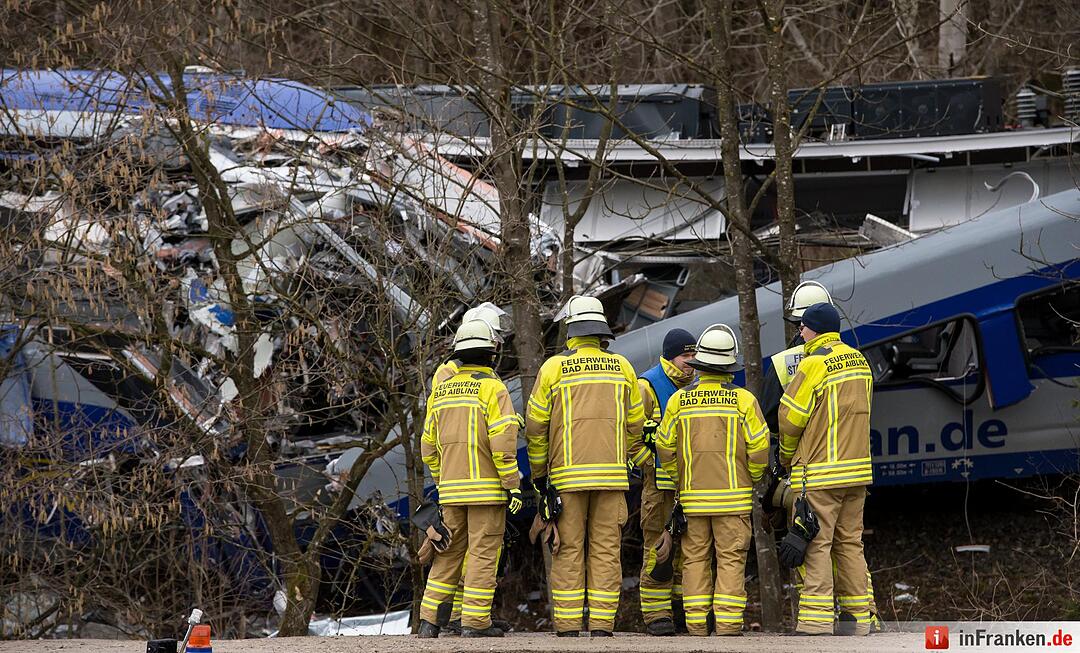Feuerwehrleute stehen am 10.02.2016 an der Unfallstelle eines Zugunglücks in der Nähe von Bad Aibling (Bayern). Die Polizei und andere Experten wollen herausfinden, wie es zu dem Zug-Unglück in Bayern kam. Das nennt man eine Ermittlung. Foto: Sven Hoppe/dpa