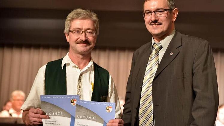 Vorstand Norbert Döll nahm für 50 Jahre Vereinsbestehen und 30 Jahre Mitgliedschaft im Nordbayerischen Musikbund aus der Hand von Peter Detsch (rechts) die Urkunden entgegen.