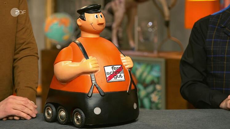 Der Moderator erkannte die freundlich lächelnde Figur auf dem Experten-Pult sofort: "Der sollte für mehr Verständnis für die LKW-Fahrer sorgen - mit allem drum und dran."