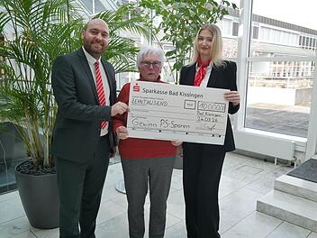 BeratungsCenter-Leiter Felix Dorn und Beraterin Charlotte Steinmetz &uuml;berreichen Maria Metz (Mitte) die symbolischen 10.000 Euro.
