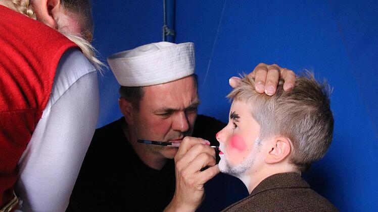 Peter Bethäuser schminkt eines der Kinder vor der Abschluss-Vorstellung. Foto: Ralf Ruppert