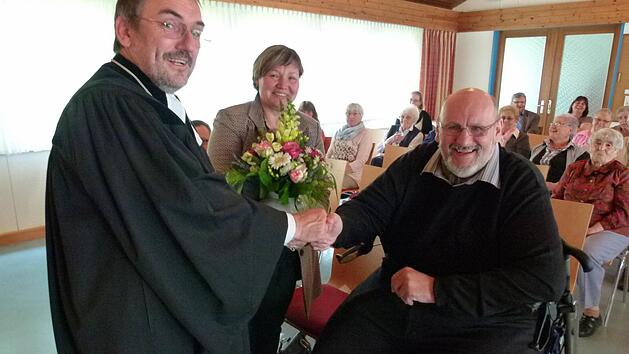 Im Kirchengemeindehaus wird Robert Kathmann (rechts) durch Dekan Andreas Kleefeld (links) und im Beisein seiner Frau Bianka Kathmann (Mitte) verabschiedet. Foto: Lothar Weidner