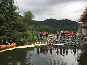 Die alarmierten Feuerwehren errichteten in der Rodach Ölsperren. Mitglieder der Wallenfelser Wehr fuhren einen Teil des Flusses mit einem Schlauchboot ab, um die Größe des Ausmaßes zu erfassen. Foto: Alexander Löffler