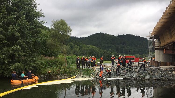 Die alarmierten Feuerwehren errichteten in der Rodach Ölsperren. Mitglieder der Wallenfelser Wehr fuhren einen Teil des Flusses mit einem Schlauchboot ab, um die Größe des Ausmaßes zu erfassen. Foto: Alexander Löffler
