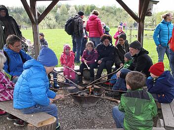 Kinder und Erwachsene grillen an der Feuerstelle.  Foto: Mathias Erlwein