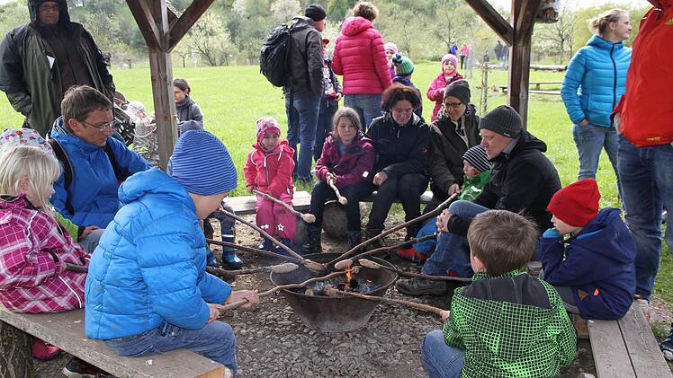 Kinder und Erwachsene grillen an der Feuerstelle.  Foto: Mathias Erlwein