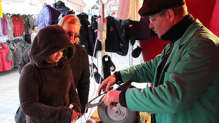 Bernhard Rösch aus Burgpreppach, der seit zwei  Jahren regelmäßig zum Kulmbacher Jahrmarkt kommt, beherrscht das traditionelle Scherenschleiferhandwerk. Und wenn es sein muss, schärft er auch schon mal eine Sichel. Fotos: Stephan Tiroch