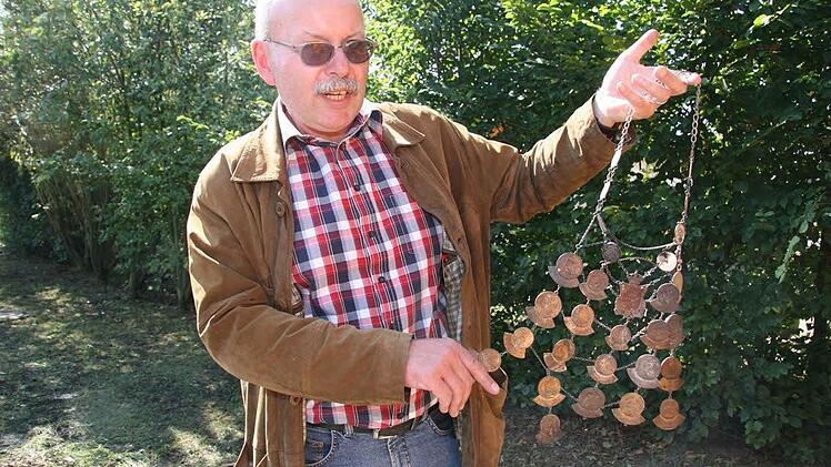Hans-Peter Gäbelein hat eine Schützenkette aus dem Brandhaufen gezogen - mit deutlichen Spuren des Feuers.