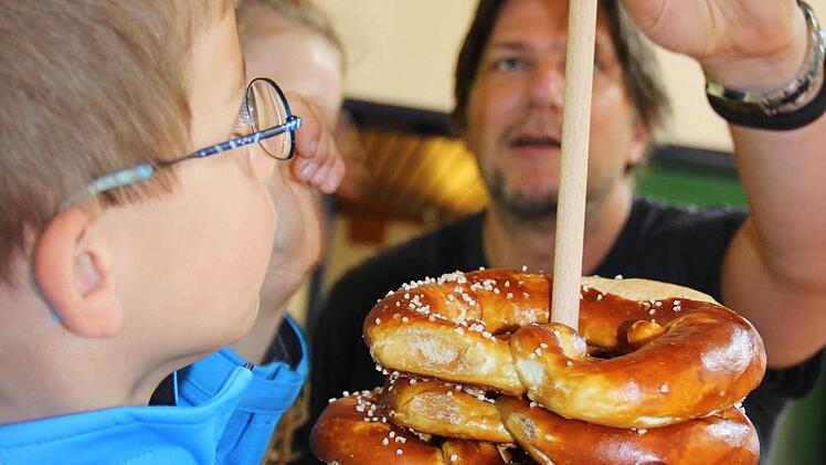 Wenn die Kinder die Brezeln selbst verkaufen, schmecken sie einfach noch mal so gut: Oliver Heinen kauft will auch gleich eine probieren.