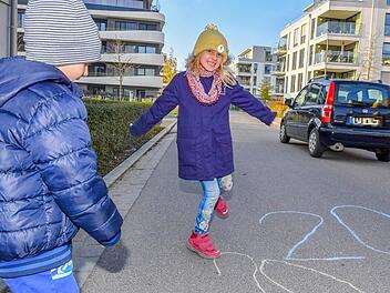 Valentin (5) und Antonia (8) weisen mit Straßenmalkreiden auf die Geschwindigkeitsbegrenzung auf der Erba-Insel hin.  Foto: Ronald Rinklef