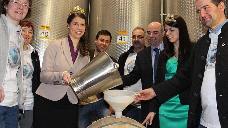 Eines der beiden 100-Liter-Holzfässer Zugspitzenwein füllt Weinkönigin Melanie Dietrich im Beisein der Ehrengäste und der "Macher" mit dem 2012er Müller-Thurgau. Foto: Pfannes