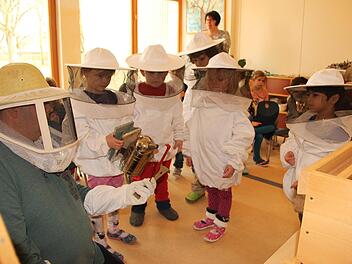 Der Vorsitzende des Imkervereins Münnerstadt und Umgebung, Dieter Schölzke, erläutert Kindergartenkindern, wie sich Imker bei ihrer Arbeit vor Bienenstichen schützen können. Heike Beudert