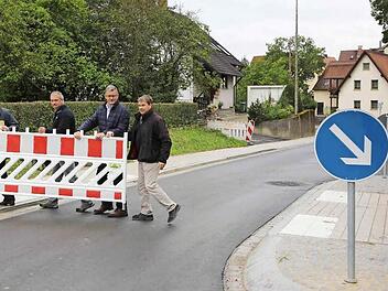 Der Bürgermeister und Vertreter des Staatlichen Bauamts räumen die letzten Barrieren in der Litzendorfer Ortsdurchfahrt beiseite. Foto: RiegerPress
