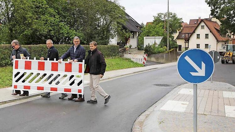 Der Bürgermeister und Vertreter des Staatlichen Bauamts räumen die letzten Barrieren in der Litzendorfer Ortsdurchfahrt beiseite. Foto: RiegerPress