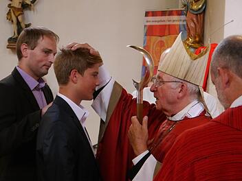 Firmung in Schondra: Pate Gunther Koop steht Firmling Niklas Beck zur Seite, als ihm Weihbischof Ulrich Boom die segnende Hand auflegt. Ihm assistiert Pfarrer Armin Haas. Foto: Oswald Türbl