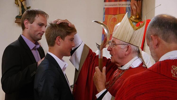 Firmung in Schondra: Pate Gunther Koop steht Firmling Niklas Beck zur Seite, als ihm Weihbischof Ulrich Boom die segnende Hand auflegt. Ihm assistiert Pfarrer Armin Haas. Foto: Oswald Türbl