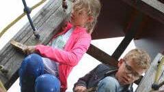 Antonia und Jonas beim "Frühjahrsputz" des Klettergerüsts auf einem Oberthereser Spielplatz.