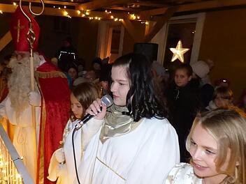 Vom Rathausbalkon aus eröffnete Christkind Viktoria Lehmann mit seinen Engeln und dem Nikolaus den Weihnachtsmarkt. Foto: Thomas Weichert