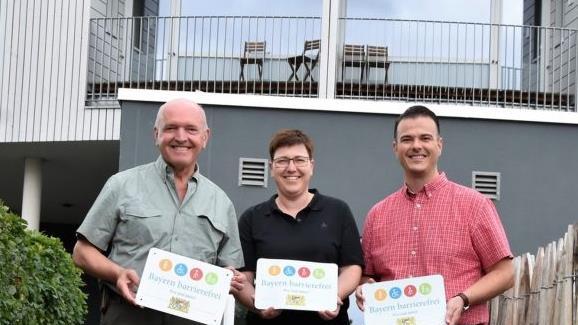 Die Umweltbildungsst&auml;tte Oberelsbach tr&auml;gt ab sofort das Signet "Bayern barrierefrei". Die Auszeichnung pr&auml;sentieren am barrierefreien Zugang zur Bildungseinrichtung (von links) Landrat Thomas Habermann, Birgit Erb, B&uuml;rgermeisterin von Oberelsbach, und Bernd Fischer, Gesch&auml;ftsf&uuml;hrer.  Foto: Tonya Schulz