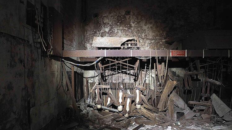 Aus der Finsternis der einstigen Kegelbahn im Felsenkeller der "Jägersruh" tauchen die Reste der Aufstellmaschine für die Kegel im Schein der Lampe auf. Foto: Christoph Winter
