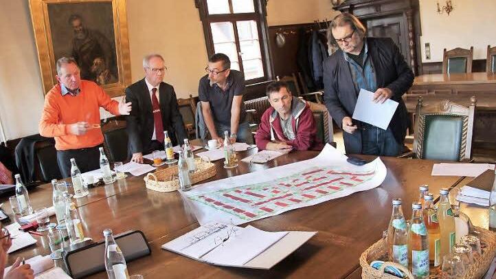 Walter Mackert (von links), Ottmar Kerner, Harald Konietzko, Klaus Schnapp und Andreas Ender werfen im Sitzungssaal des Rathauses einen Blick auf den Lageplan.