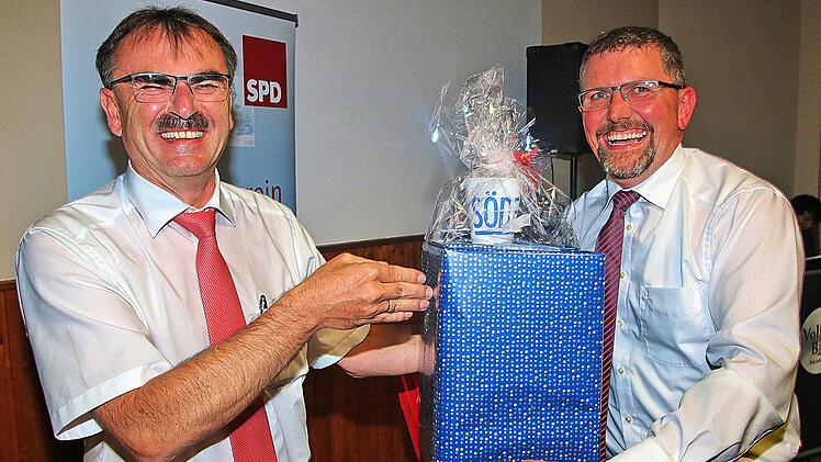 Hintersinniges Geschenk: eine Kaffeemaschine und eine Söder-Tasse  überreichte der Nüdlinger Bürgermeister CSU-Ortsvorsitzende Harald Hofmann (links) dem SPD-Ortsvereinsvorsitzenden Volker Schäfer. Foto: Dieter Britz