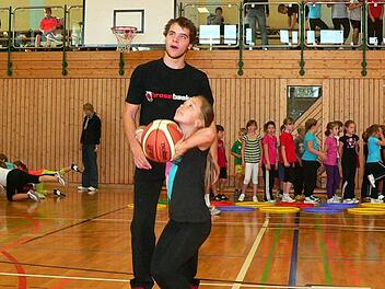 Für eine Neunjährige hängt der Korb ganz schön weit oben. Coach Johannes Wunder übt mit Lara Sesselmann von der Nordhalbener 4. Klasse den Wurf hinein.  Foto: Norbert Neugebauer