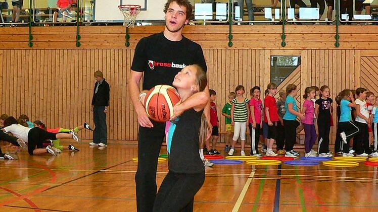 Für eine Neunjährige hängt der Korb ganz schön weit oben. Coach Johannes Wunder übt mit Lara Sesselmann von der Nordhalbener 4. Klasse den Wurf hinein.  Foto: Norbert Neugebauer