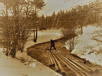 Dieses aussagestarke Bild, etwa um 1920 am Doberbach unterhalb von Tschirn bei der beginnenden Schneeschmelze aufgenommen, dokumentiert eindrucksvoll die einst problematischen Fahrten der Floßknechte auf ihren Kuppeln. Bei diesen akrobatischen Einsätzen waren die Männer gnadenlos Kälte und Nässe ausgesetzt. Repro: Gerd Fleischmann