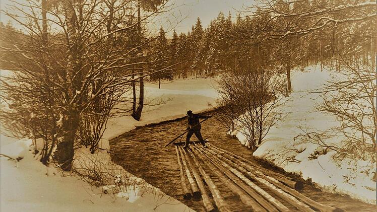 Dieses aussagestarke Bild, etwa um 1920 am Doberbach unterhalb von Tschirn bei der beginnenden Schneeschmelze aufgenommen, dokumentiert eindrucksvoll die einst problematischen Fahrten der Floßknechte auf ihren Kuppeln. Bei diesen akrobatischen Einsätzen waren die Männer gnadenlos Kälte und Nässe ausgesetzt. Repro: Gerd Fleischmann