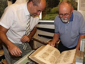 Bürgermeister Johannes Krapp und Museumsleiter Friedel Auer (rechts) blättern in einem besonderen Schatz: Ein Kräuterbuch aus dem Jahr 1613, in dem 3000 Kräuter beschrieben sind.Evi Seeger