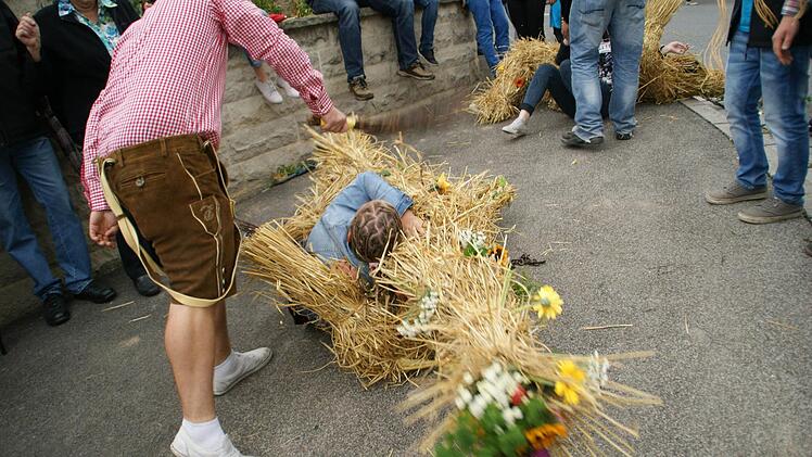 So geht es jungen Mädchen am Kirchweihmontag in Kirchaich: Der Strohbär stürmt auf Lea zu - und Papa sitzt lachend daneben. Das Ganze endet natürlich am Boden. Foto: Sabine Weinbeer
