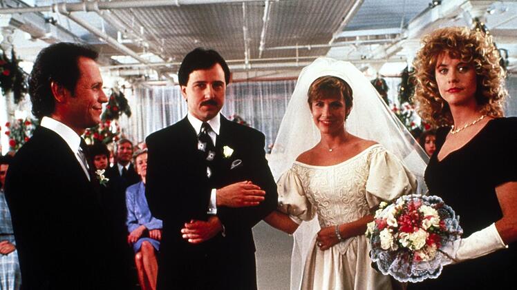Harry (Billy Crystal, links) und Sally (Meg Ryan, rechts) sind bei der Hochzeit ihrer Freunde Jess (Bruno Kirby) und Marie (Carrie Fisher) Trauzeugen.