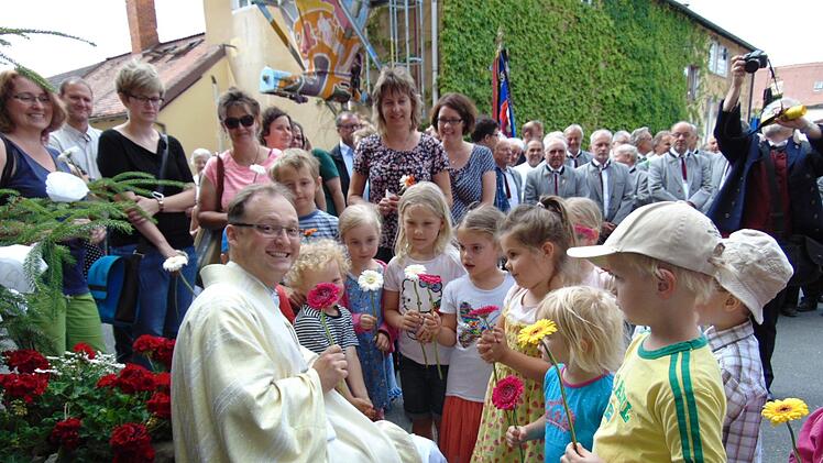 Die Weißenoher Kindergartenkinder überreichen ihrem Florian Sassik zu seiner Primiz Blumen.  Foto: Petra Malbrich