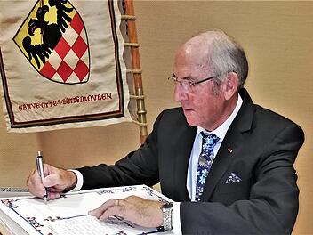 Werner Vogel trägt sich als neuer Ehrenvorsitzender ins Goldene Buch des Reiterswiesener Heimatvereins ein. Foto: Sigismund von Dobschütz