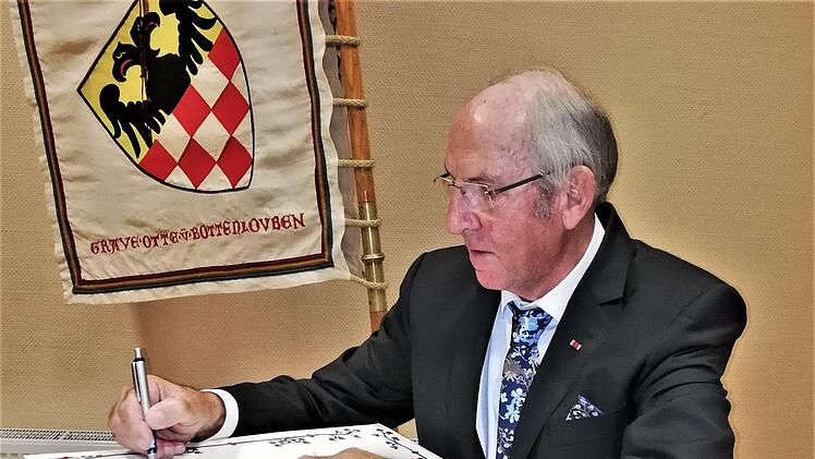 Werner Vogel trägt sich als neuer Ehrenvorsitzender ins Goldene Buch des Reiterswiesener Heimatvereins ein. Foto: Sigismund von Dobschütz