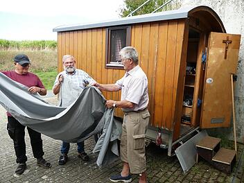 Hans Lyer, Heribert Tr&auml;ger und Paul Hain (von links) bringen an den Kapellenwagen eine Plane an: &bdquo;als Zelt Gottes unter den Menschen&ldquo;.Marion Kr&uuml;ger-Hundrup