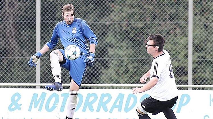 Der Lisberger Torwart Timo Sennefelder schlägt den Ball vor Michael Baldauf weg.