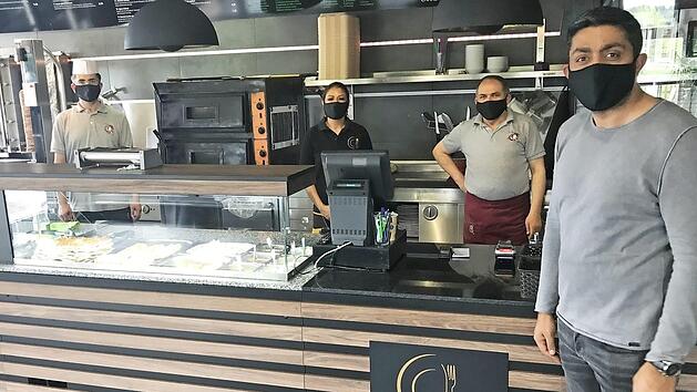 Abstand halten ist auch für die Mannschaft von Adem Deliduman (vorne rechts) oberstes Gebot. Mit einer "Rumpfmannschaft" hält der Gastronom seinen Heßdorfer Betrieb am Laufen.  Foto: Michael Busch