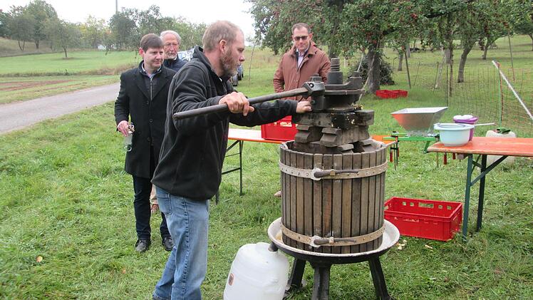 Christian Reusch bediente die Kelter aus der der frische Apfelsaft floss. Die Flaschenproduktion wird dann natürlich nicht mit der Handpresse funktionieren, sondern über zwei Keltereien. Foto: Winfried Ehling