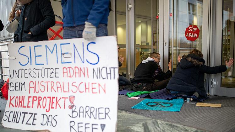 Die Teilnehmer protestieren gegen einen Siemens-Auftrag in Australien. Foto: Daniel Karmann/dpa