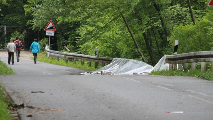 Obwohl die Kreisstraße LIF 7 abgesperrt und mit Gittern angesichert ist, setzen sich am Sonntagmittag Neugierige über das Verbot hinweg und laufen die Straße entlang. Durch die tagelangen Regenfälle ist die Straße nach rechts, zum Main hin abgesackt. Im Kurvenbereich Richtung Weingarten sind Bäume umgestürzt oder drohen, auf die Fahrbahn zu fallen. Fotos: Matthias Einwag