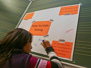 Viktoria setzt ihre Unterschrift unter den Kul-Kids-Vertrag.