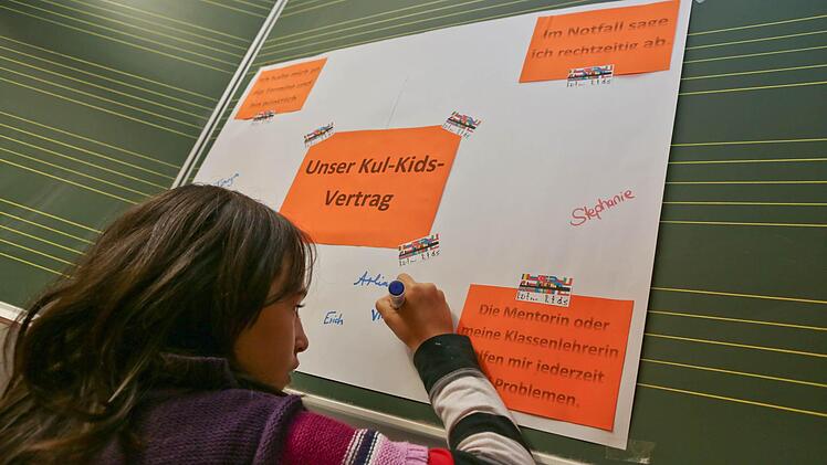 Viktoria setzt ihre Unterschrift unter den Kul-Kids-Vertrag.