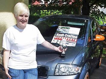 Stolz posiert Laura Schneider vor ihrem Audi mit dem Pokal, den sie als Sonderpreis für ihr Tattoo erhalten hat.  Foto: Heike Schülein
