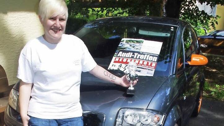 Stolz posiert Laura Schneider vor ihrem Audi mit dem Pokal, den sie als Sonderpreis für ihr Tattoo erhalten hat.  Foto: Heike Schülein