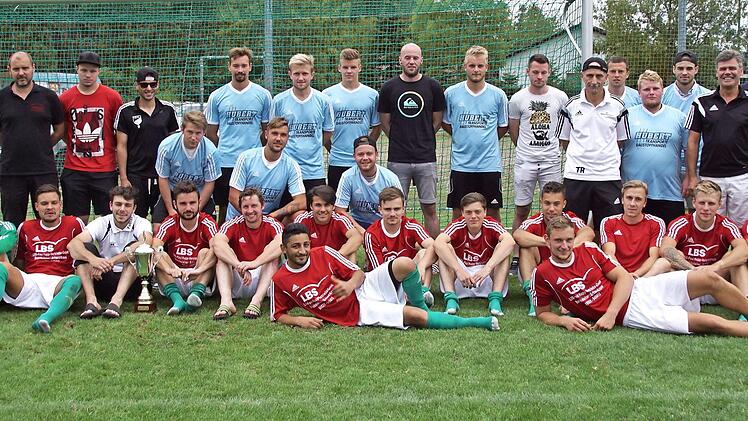 Zum zweiten Mal in Folge sicherte sich der RSV Unterschleichach den Oberaurach-Pokal mit einem 1:0 im Endspiel gegen den TSV Kirchaich. Unser Bild zeigt die beiden Mannschaften mit den RSV-Vorsitzenden Judith Ullrich und Erik Schuhmann (hinten von links), TSV-Vorsitzendem Norbert Hartmann und Bürgermeister Thomas Sechser (Dritter und Vierter von rechts). Foto: sawe