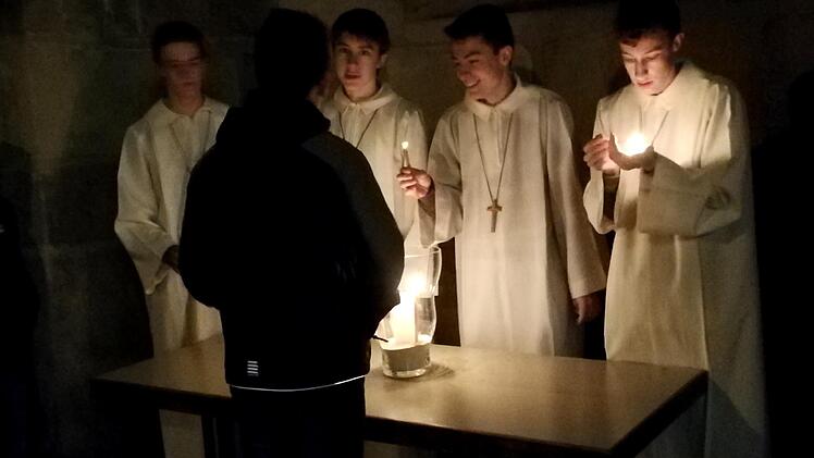 Nach dem Gottesdienst verteilen die Ministranten das Licht von Bethlehem.